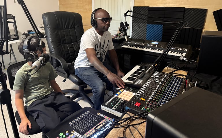 Two musicians in a recording studio working at music production equipment and keyboards